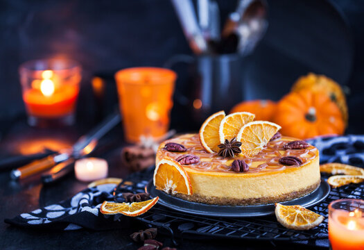 Delicious pumpkin and orange cheesecake decorated with caramel sauce and pecan