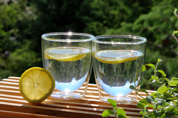 Two glasses of water and lemon served in the garden