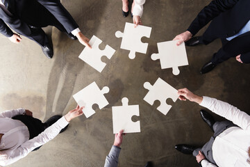 Businessmen working together to build a big puzzle. Concept of teamwork, partnership, integration...