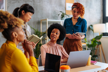 Multiracial female business meeting in hipster startup office.