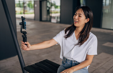 Young Japanese woman blogging in the public