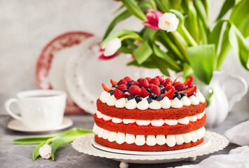 Delicious homemade red velvet cake decorated with cream and fresh berries