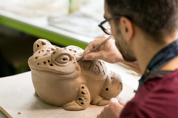 Ceramist Dressed in an Apron Sculpting Statue from Raw Clay in the Bright Ceramic Workshop.