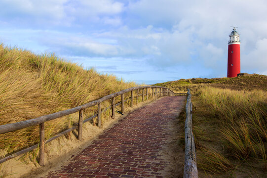 Brick Road to Lighthouse Texel on Blue Cloudy Sky background Outdoors. National Park Duinen van Texel, Texel Island, Netherlands