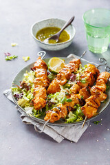 Chicken skewers with lime and mint and spicy sauce.