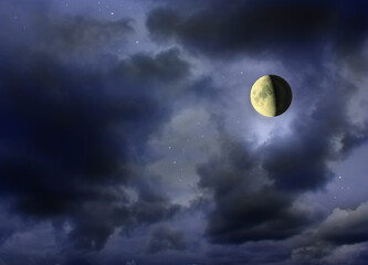 Naklejka na ściany i meble Moon glowing in the dark cloudy night sky with stars. Cosmic landscape. Moon in starlit night