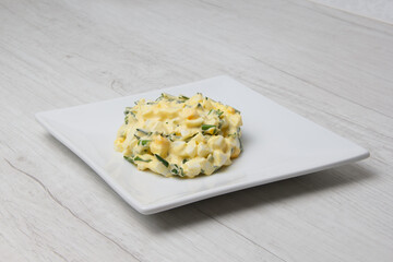 portion of boiled egg salad with herbs and white sauce. set . selective focus 