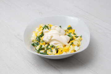 chopped finely boiled eggs and green onions with mayonnaise in salad photo from the series. selective focus 