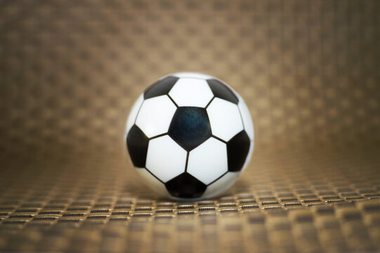 A toy soccer ball on an artificial background. Concept of the game of football