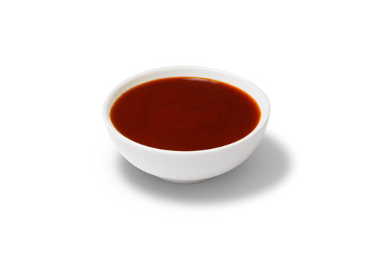Red sauce in a gravy boat. White background