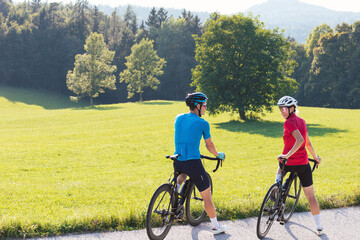Obraz premium Man and woman couple cyclist during a ride on a countryside road