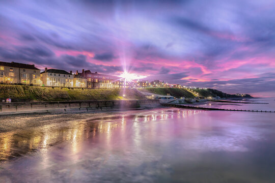 Sunburst over Cromer town - As dusk appears, the soft lights of streets and buildings come on. Cromer has one of the best, and flourishing, piers in England and the only surviving end of pier show in 