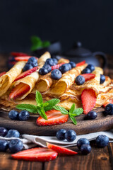 Healthy vegan pancakes crepe with blueberry and strawberry.