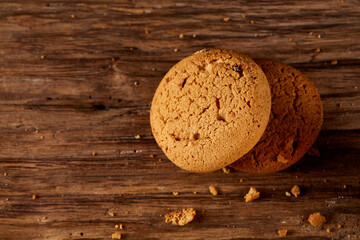 Pile of oat cookies on wooden table, close-up, selective focus. Crunchy stack. Delicious snack. Homade bakery. Tasty biscuit. Nutritious sweet food on rustic background. Healthy food concept.