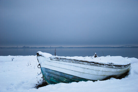 Winter paused old wooden rowboat by the coast of the swedish island Oland in the Baltic Sea