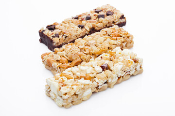 Protein cereal energy bars with nuts and caramel and chocolate for breakfast on white background
