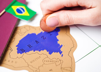 Travel holiday to Brazil concept with passport and flag with female hand choosing Brazil on the map