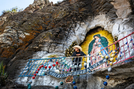 Man visiting virgin of guadalupe painting on rocks in mexico