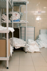 industrial laundry in a hotel dirty bed linen lies on the floor sorted before being loaded into the...