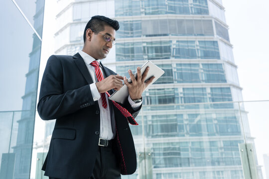 Indian businessman analyzing financial report on a tablet PC indoors at the office