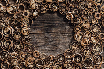 Wood spiral shavings on a vintage workbench background, blank copyspace at center: carpentry, woodworking and craftsmanship concept