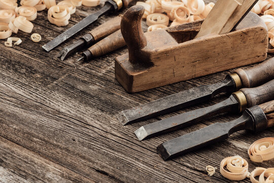 Old carving and woodworking tools and wood shavings on a vintage workbench: carpentry, woodworking and craftsmanship concept