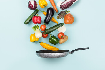 Fresh healthy vegetables falling in a pan, healthy food and cooking concept
