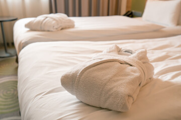 the interior of a luxury hotel room after cleaning white robes folded on the bed concept of cleanliness and hospitality