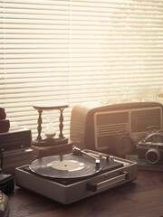 Vintage retro revival objects and appliances assortment on a table, turntable record player on the foreground