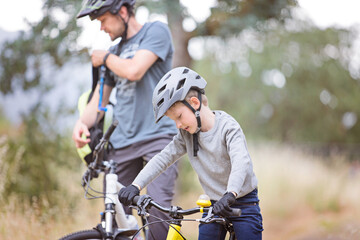 Fototapeta premium family of two, young father and cheerful son, enjoying bike riding, active family concept