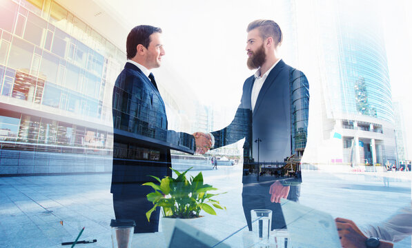 Handshaking business person in the office. concept of teamwork and business partnership. double exposure
