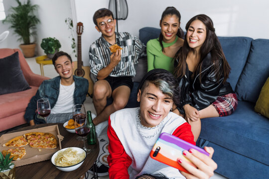 latin LGBT friends taking photo selfie with mobile phone at home in Mexico, Hispanic homosexual and lgbtq community in Latin America