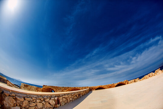 bay of Chania at sunny summer day, Crete, Greece. Deep blue sky and yellow stone wall