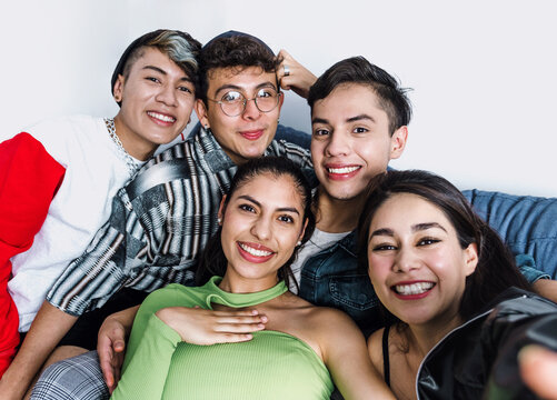 Young latin LGBT friends portrait celebrating gay pride month at home in Mexico, Hispanic homosexual people from lgbtq community in Latin America