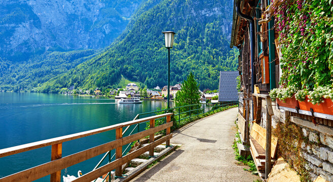 Hallstatt Austria vintage architecture and old houses in picturesque austrian mountains Alps on lake Hallstattersee. Old street along the lake banks with wooden fence and lantern.