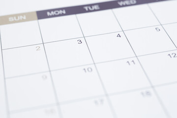 Closeup of dates on blank calendar page. Simple timetable planning for appointment schedule and business work management. Selective focus on background with vintage minimal style.