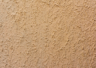 fragment of beige wall with decorative plaster of waves, full frame