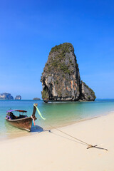 Fototapeta na wymiar Traditional Wooden Longtail Boat anchored on Railay Beach in Krabi Province Southern Thailand, Longtail Boats are used as water taxis between the beaches and islands of krabi a popular tourism destina