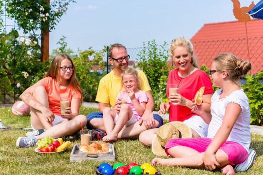 Happy family having picnic in garden front of their home