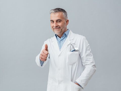 Smiling friendly doctor giving a thumbs up, medical test and healthcare concept