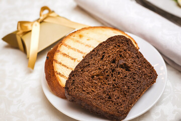 Wedding bonbonniere in beautiful gold packing with bow and two hot toasts laying on the festive table