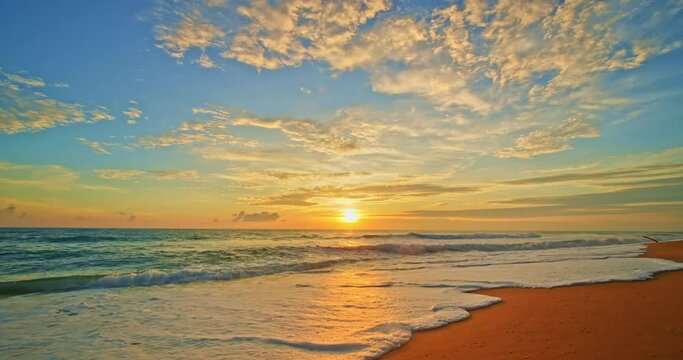 Slow Waves crashing on sandy shore in slow motion,Amazing ocean beach in sunrise or sunset light over sea,Beautiful light colorful nature sky and clouds background