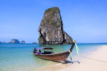 RAILAY BEACH, KRABI, THAILAND â?? APRIL 8 2015 Traditional Wooden Longtail Boat anchored on Railay Beach in Krabi Province Southern Thailand, Longtail Boats are used as water taxis between the beaches