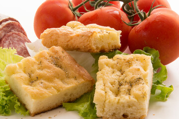 Italian rustic appetizer, tasty focaccia, salami tomatoes