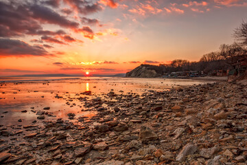 Exciting sunset/sunrise on the rocky coast with water reflection