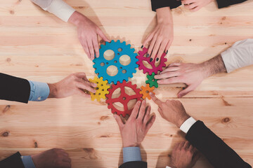 Teamwork of businesspeople work together and combine pieces of gears. Partnership and integration...