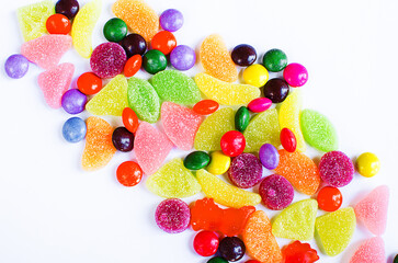 Scattered colored candy on a limited white background