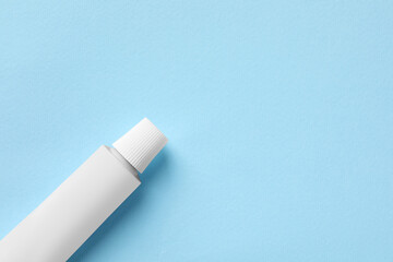 Tube of ointment on light blue background, top view. Space for text - obrazy, fototapety, plakaty