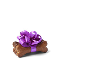 Bone shaped dog cookies with purple bow on white background, space for text