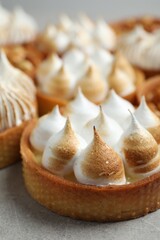 Many tartlets on grey table, closeup. Delicious dessert
